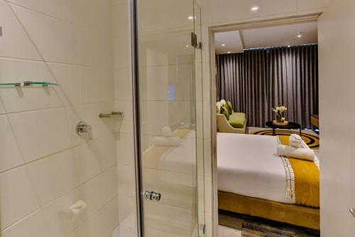 a bathroom with a shower and a bedroom at ZIMBALI BOULEVARD SUIT 260 in Ballito