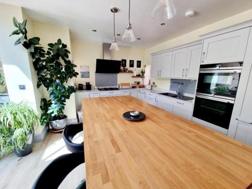 a kitchen with a wooden table in a room at Cosy Family Haven: Spacious 3-Bedroom Retreat in Christchurch in Iford
