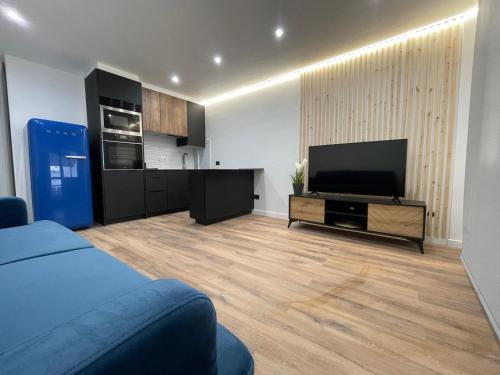 sala de estar con TV y cocina en Apartamentos JL&DN Primera Línea Playa Silgar *Sansenxo*, en Sanxenxo