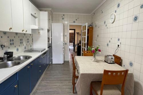 uma cozinha com armários azuis e uma mesa com cadeiras em Apartamento céntrico en Azpeitia em Azpeitia
