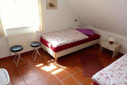 ドランスケにあるFerienhaus-Sonnenblumeの小さなベッドルーム(ベッド1台、スツール2台付)