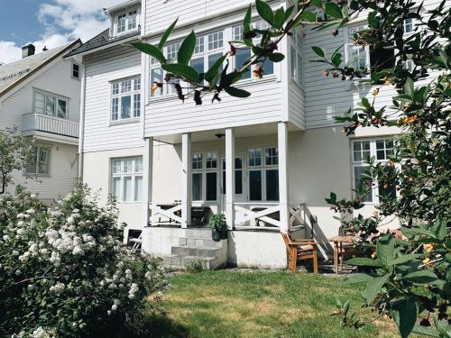 a white house with a table and a chair at Valldal Sentrum Overnatting in Valldal