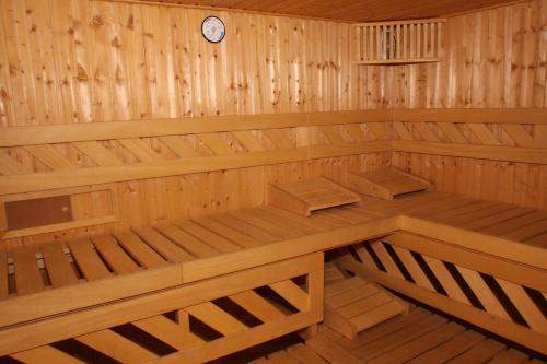 a wooden sauna with a clock on the wall at Hotel Bucegi Portile Regatului in Paraul Rece