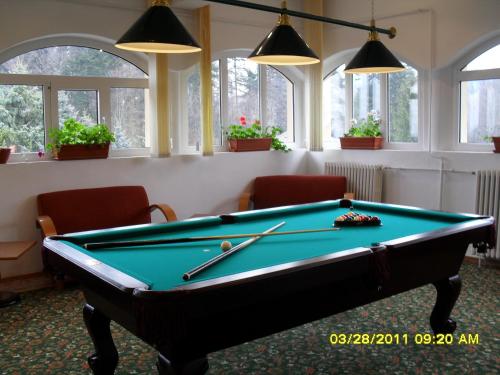 a pool table in a room with windows at Hotel Bucegi Portile Regatului in Paraul Rece