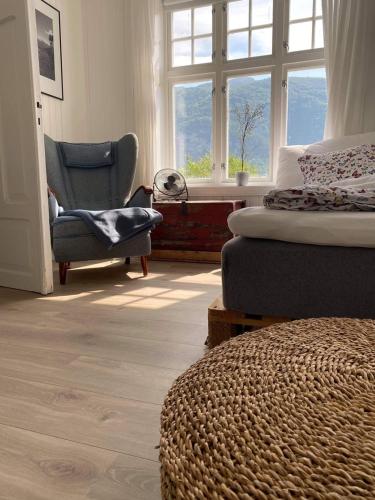 a bedroom with a bed and a chair and a window at Valldal Sentrum Overnatting in Valldal