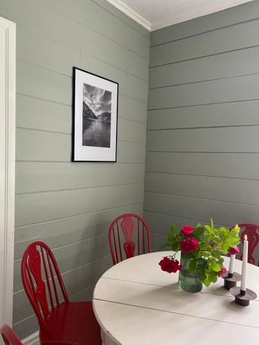 a dining room with a table and red chairs at Valldal Sentrum Overnatting in Valldal