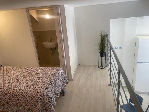 a bedroom with a bed and a bathroom with a sink at appartamento francy solare in Castellammare del Golfo
