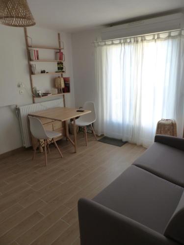 un salon avec une table et des chaises et une fenêtre dans l'établissement Chambre privative près de l'étang de Thau, à Sète