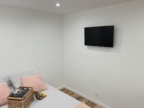 un salon blanc avec un canapé et une télévision dans l'établissement Chambre Mignet, à Aix-en-Provence