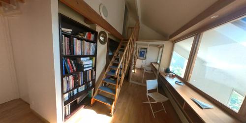 Pousada Bertin في شاتو: غرفة بها درج ومكتب مع كتب