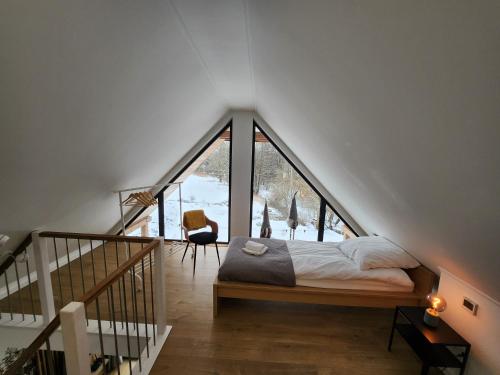 Bett in einem Zimmer mit einem großen Fenster in der Unterkunft Brzuchem do góry in Chocieszow
