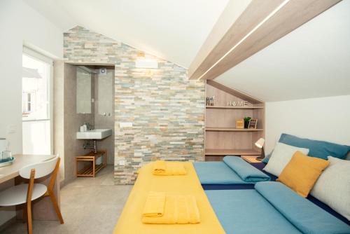 uma sala de estar com um sofá azul e uma mesa em Old Town Rooms Piran em Piran
