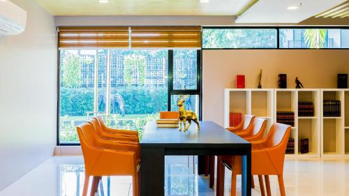ein Esszimmer mit einem schwarzen Tisch und orangefarbenen Stühlen in der Unterkunft The Star Hill Condo Luxury Suites in Chiang Mai