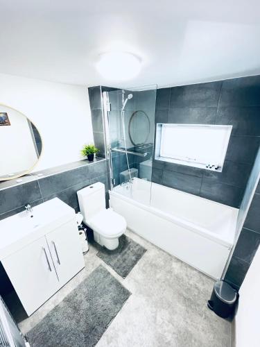 a bathroom with a toilet and a tub and a sink at 2 Bedroom Modern House in Cambridge city centre in Chesterton