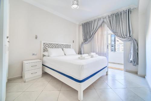 a white bedroom with a bed and a window at Apartment for rent with 2 bedrooms in Tangier