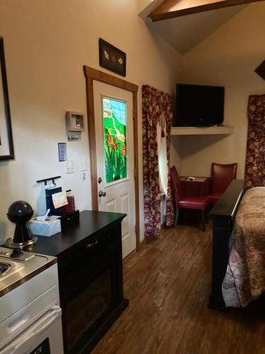 Cette chambre comprend un lit, un bureau et une cuisine. dans l'établissement All Seasons Treehouse Village, à Eureka Springs