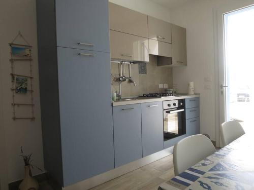 a kitchen with white cabinets and a stove at Torre Vado...spiaggia e relax in Torre Vado