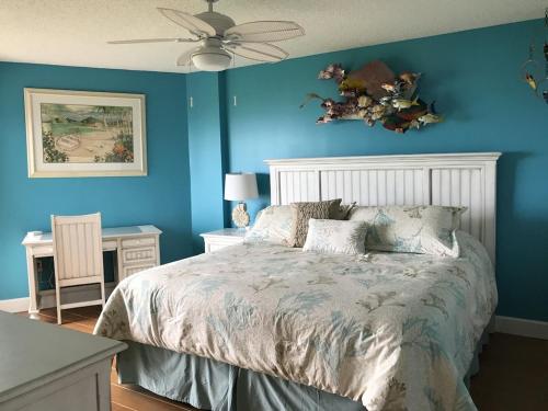 a blue bedroom with a bed and a ceiling fan at Tropical Daze Oceanfront Paradise in Tavernier