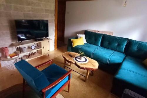 a living room with a blue couch and a table at Durmitor Chill Chalet in Žabljak