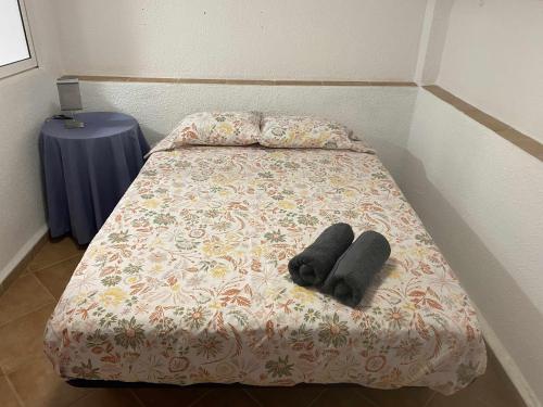 Una cama con dos objetos negros sobre ella. en Casa Las Emilias en La Cañada, en Partida de La Cañada