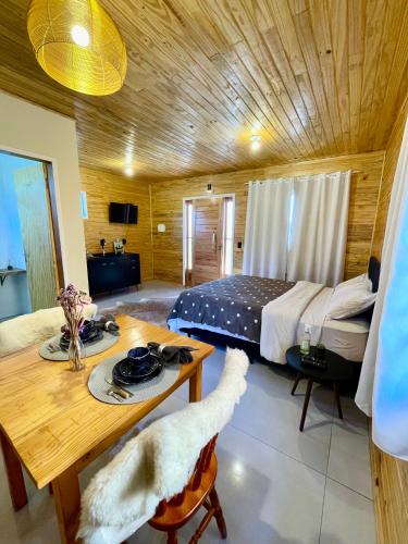 1 dormitorio con cama y techo de madera en Cabanas Kuntze, en Urubici