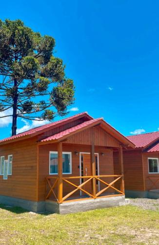 una pequeña casa de madera con techo rojo en Cabanas Kuntze, en Urubici