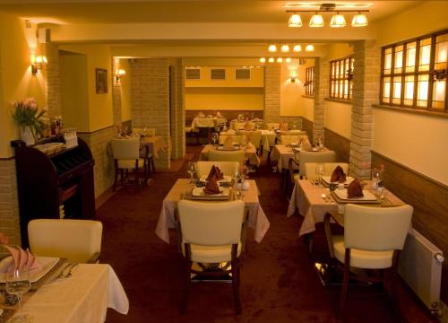a restaurant with tables and chairs and a piano at Penzion Aurooms in Zlatníky