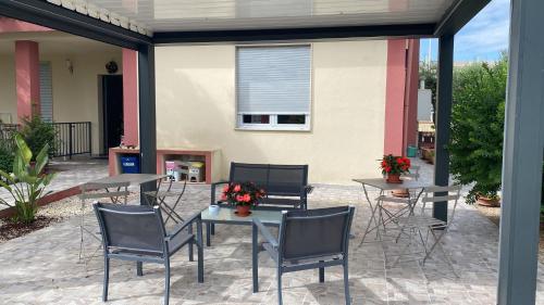 a patio with tables and chairs with flowers on it at B&B Villa Nora in Quartu SantʼElena