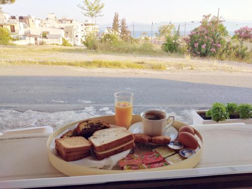 un plato de comida con pan y una taza de zumo de naranja en Rooms-Studio Anagnostou, en Loutra Edipsou