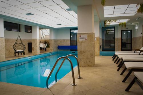 een zwembad in een hotel met tafels en stoelen bij Апартамент в MountainLake in Smolyan