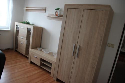 une grande armoire en bois dans une chambre avec une commode dans l'établissement Prázdninové ubytování - celý byt jen Váš, à Litomyšl