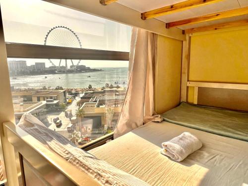 a room with a bed and a window with a view at York Backpackers - Jumeirah Beach in Dubai