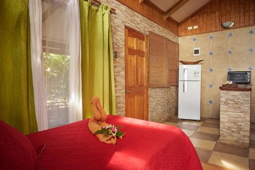 a kitchen with a red table with a animal on it at Cabañas Maria Hau in Hanga Roa