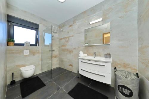 ein Badezimmer mit Waschbecken, Toilette und Dusche in der Unterkunft Villa Good Vibes with heated pool in Vrsi