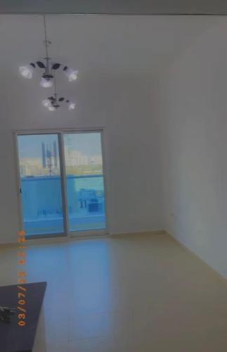 een kamer met drie ramen en een witte muur bij Little Hut City Towers in Ajman 