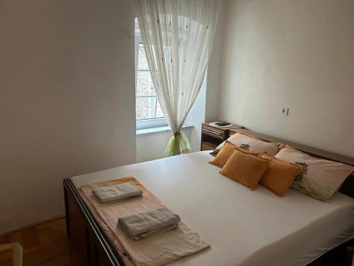 1 dormitorio con 1 cama con 2 toallas en Apartments Bella, en Kotor
