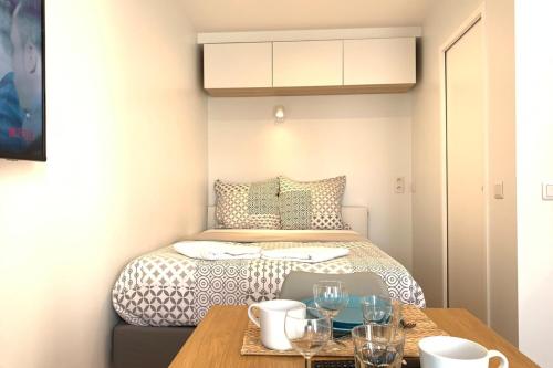 une petite pièce avec un lit et une table dans l'établissement Cosy studio M1 RER BC500m Orly 20 min Netflix, à Massy