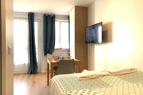 une chambre d'hôtel avec un lit, un bureau et une télévision dans l'établissement Cosy studio M1 RER BC500m Orly 20 min Netflix, à Massy