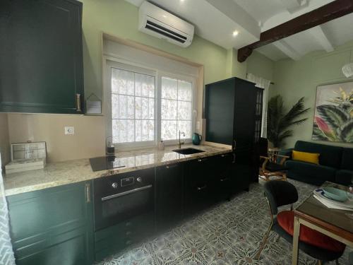 eine Küche mit schwarzen Schränken und ein Wohnzimmer in der Unterkunft Esmeralda Apartment With Free Private Underground Parking in Valencia