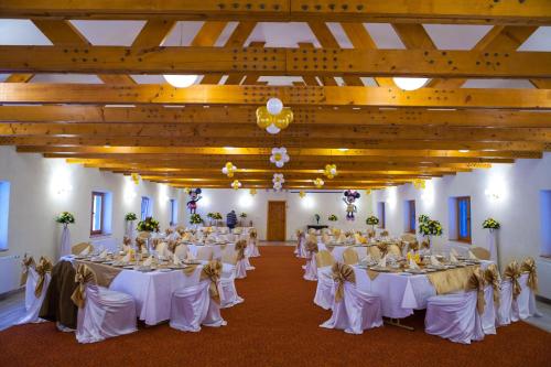 a room filled with tables with white tablecloths at Hotel Bucegi Portile Regatului in Paraul Rece
