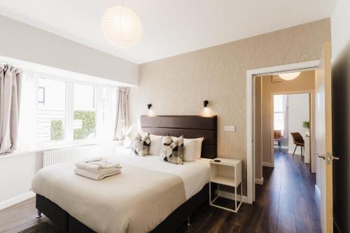 ein Schlafzimmer mit einem großen Bett und einem Fenster in der Unterkunft Design Suites Lytham in Lytham St Annes