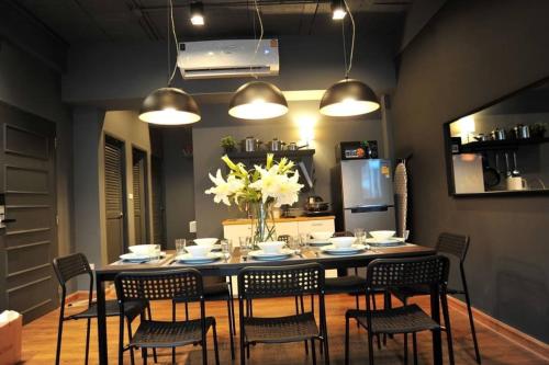 a dining room table with chairs and a vase of flowers at STAY-DIUM House Huamark in Ban Bang Toei (1)