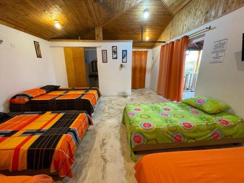 um quarto com três camas num quarto em Cabaña Caminito- Cerca al mar al lado de Turipaná, 7 a 12 personas em Carretal