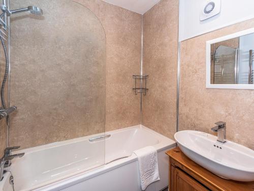 a bathroom with a bath tub and a sink at 2 Mount Pleasant in Looe