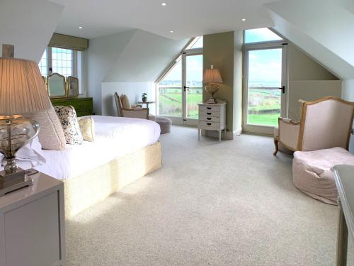 a large bedroom with a large bed and windows at The Gatehouse - UK36939 in Lamerton