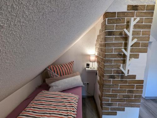 Cette chambre comprend un lit à côté d'un mur en briques. dans l'établissement Ferienhaus kleine Remise, à Langelsheim