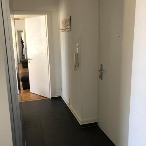 - un couloir avec deux portes blanches et un miroir dans l'établissement Ein Zimmer in einer 2-Zimmer-Wohnung im Zentrum, à Zurich