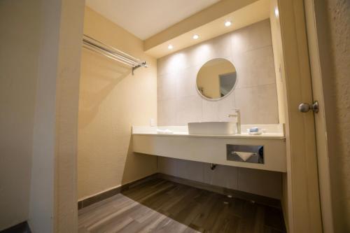 La salle de bains est pourvue d'un lavabo et d'un miroir. dans l'établissement Hotel Colonial Ciudad Juarez, à Ciudad Juárez