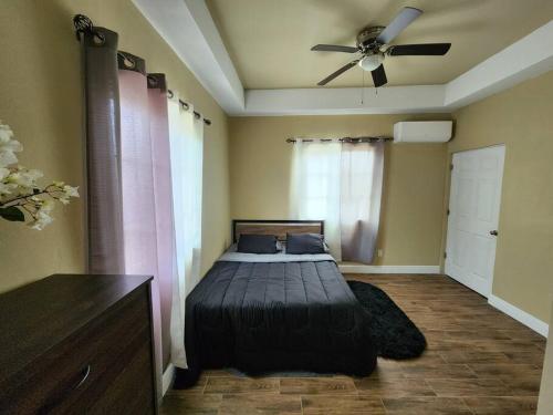 sypialnia z łóżkiem i wentylatorem sufitowym w obiekcie StoneSide Villa w mieście Providenciales