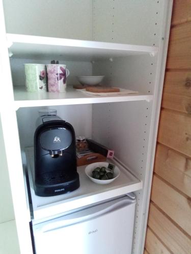 un réfrigérateur avec un appareil noir à l'intérieur dans l'établissement Suite parentale dans maison en bois calme - frigo, vue jardin, à Carcans